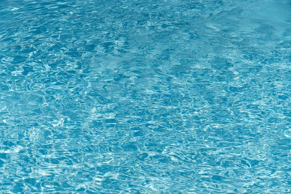 游泳池背景中的蓝色水 在有阳光反射的游泳池里的波纹水 蓝色游泳池波纹水细节 — 图库照片