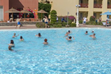Fitness kavramı, bir fitness sınıfı, bir grup insan aqua aerobik havuzu bir yaz günü açık havada üzerinde çalışmaktadır. Bulanık.
