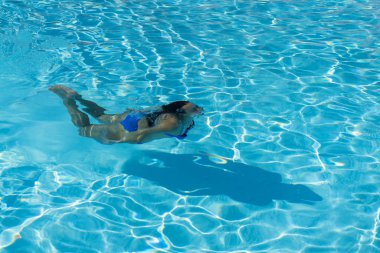Kadın bir mavi su üzerinde yüzme mayo ile. Sualtı kadın portre yüzme havuzunda mavi bikini ile