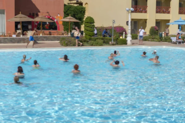 Fitness kavramı, bir fitness sınıfı, bir grup insan aqua aerobik havuzu bir yaz günü açık havada üzerinde çalışmaktadır. Bulanık.