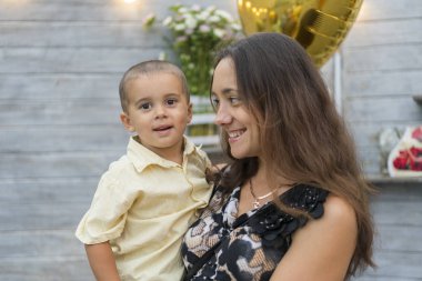 Anne bir çocuk onun kollarında tutar. Mutlu bir aile. Genç kucağında bebeği tutan anne ve anne çocuk litso okşadı. Portret anne ve küçük oğlu.