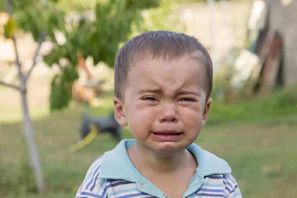 Маленький хлопчик плаче. Плакати. Портрет хлопчика. Кавказький дитина дивиться на камеру. Чарівна хлопчик дитина плаче зі сльозами на очах. злий характер. істерика. — стокове фото