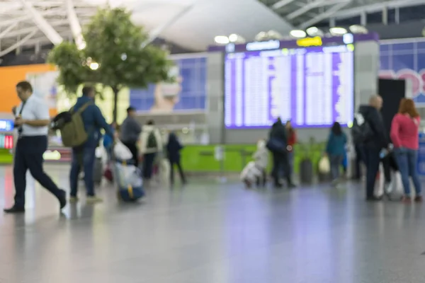 Pasażerów na lotnisku w pobliżu tablicy informacyjnej. Niewyraźne — Zdjęcie stockowe