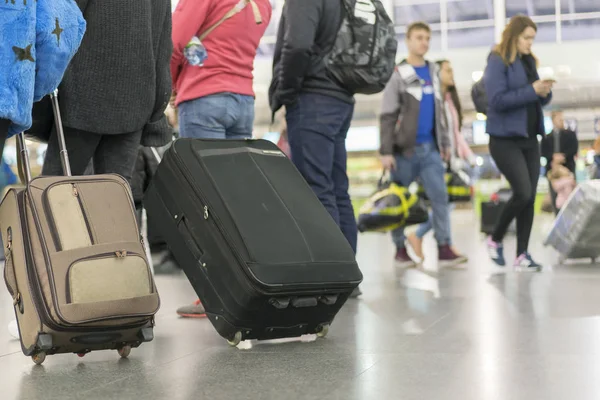 Пассажиры с чемоданом в аэропорту — стоковое фото