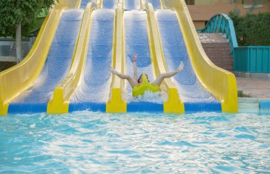kız sürgülü su parkı. Aqua park su slaytta aşağı kayan kadın