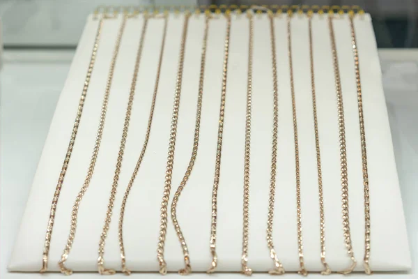 Gold chains on the showcase. gold jewelry. Gold necklace in red background on showcase jewelry - luxury brilliant jewelry platinum chain gold.