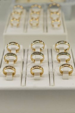 altın yüzük mağazası. Altın alyans vitrinde. Alyans set. dikey fotoğraf