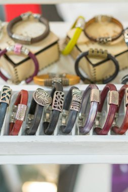 Şık deri bilezik dükkanda. Çok çeşitli deri ve tekstil bilezikler. Deri dükkanda çok renkli bilezikler. dikey fotoğraf.