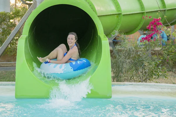 비키니에 여자에 재미는 수영장 낙하산에 내린다 슬라이드를 타고입니다 반지에 주황색 — 스톡 사진