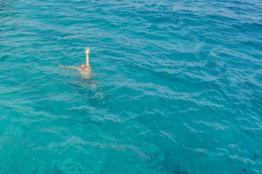 Yükseltilmiş silah ile ilgili yardım isteyen denizde boğulan adam. Adam Denizde boğuluyor. denizde boğulma ve yardım için el sallayarak adam