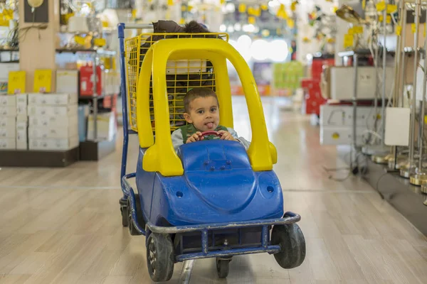 boy in a trolley at an industrial store.