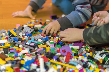 Yerdeki renkli plastik tuğla kapatın. Erken öğrenme. Çocuk yerdeki plastik Oluşturucu. Küçük bir Oluşturucu çocuk el oynayın