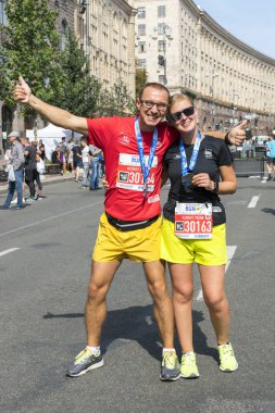 Ukrayna, Kiev, Ukrayna 09.09.2018 bir mutlu çift koşucu bir maraton sonra. Çalıştırdıktan sonra mutlu zayıf kaçakçıları. dikey fotoğraf.