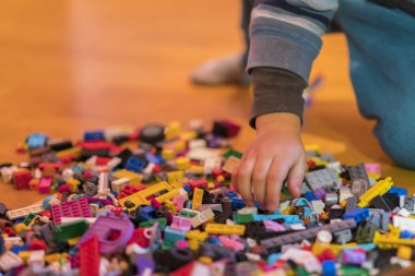 Yerdeki renkli plastik tuğla kapatın. Erken öğrenme. Çocuk yerdeki plastik Oluşturucu. Küçük bir Oluşturucu çocuk el oynayın