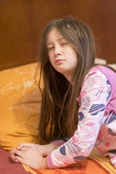 child sleepy yawning in bed. Sleepy little girl on the bed. vertical photo.