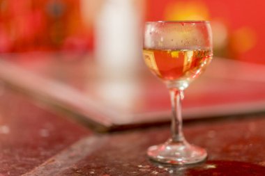 Şarap kadehi üzerinde arka plan bulanık. Cam masa üzerinde beyaz şarap ile. kopya alanı