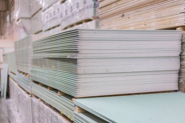 Alçıtaşı alçıtaşı pakette. Alçıtaşı yığını inşaata hazırlanıyor. İnşaat dükkanında alçıpanlı palet. İnşaat malzemeleri. Alçıpan deposu