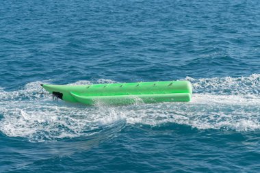 şişme yeşil muz gemisi denize boşalt. Yaz günü - muz gemisi denizde su yüzeyinde eğlenmek için Banana Boat