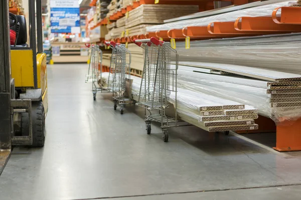 construction cart in the building store. Carts loaded with boards. shop of building materials. Racks with boards, wood and building material. loaded cart in a hardware store