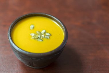 Kabak Krem-çorba kabak çekirdeği ve Baharatlar, yukarıdaki görünümünden, stüdyo eklenmesi ile vurdu. Kabak çekirdeği ve Baharatlar, görünümünün üst eklenmesi ile kil plaka kabak krem-çorba. kopya alanı