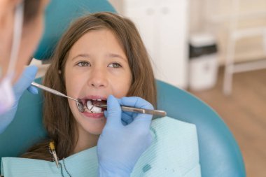 Diş check-up dişçi ofisinde. Küçük kız dişçi ofisinde resepsiyonda. Dişçi ofisinde küçük kız sitts