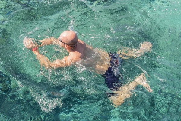man with snorkel mask tuba and snorkel in sea. Snorkeling, swimming, vacation. Tourists are engaged in snorkeling in the open sea. Holidays in the seaside resort