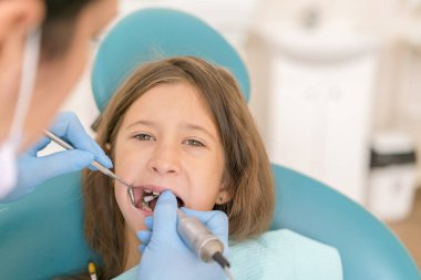 diş hekimi ve küçük kız hasta. Sevimli küçük kız onun ağız diş hekimi, ağız boşluğu incelenmesi sırasında geniş açılış Close-Up