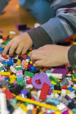 Yerdeki renkli plastik tuğla kapatın. Erken öğrenme. Çocuk yerdeki plastik Oluşturucu. Küçük bir Oluşturucu çocuk el oynayın.