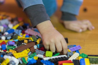 Yerdeki renkli plastik tuğla kapatın. Erken öğrenme. Çocuk yerdeki plastik Oluşturucu. Küçük bir Oluşturucu çocuk el oynayın
