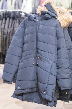 Giysiler dizi, kat raf giyim Dükkanı iç arka plan üzerinde. Kış ceket bir mağaza. dikey fotoğraf