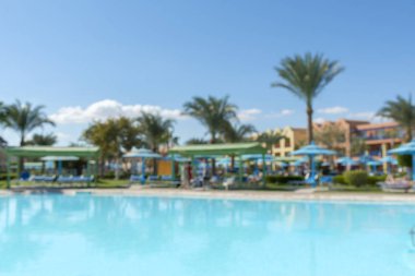 Havuz mavi serin gökyüzü ve tropikal palmiye ağacı ile yaz arka plan bulanıklık. Yaz bulanıklık arka plan havuz partisinde tropikal resort otel Yüzme Havuzu tatil tatil dinlenme yer