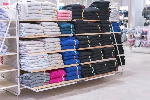 Neat stacks of folded clothing on the shop shelves. Color folding shirt In a neatly organized clothing store