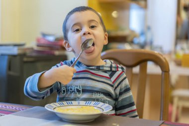 Komik bebek püresi yiyor. Mutlu bebek bebek çocuk kaşık itsel yiyor