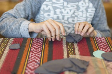 Bir iğne ve iplik ile küçük kız. oluşturma. küçük kız keçe yapılan oyuncak diker