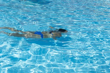 Yüzme havuzunda dalış kadın. Genç güzel kız havuzda. Esmer güneşli açık sıcak suda rahatlatıcı. Üst görüntülemek yakın yavaş hareket