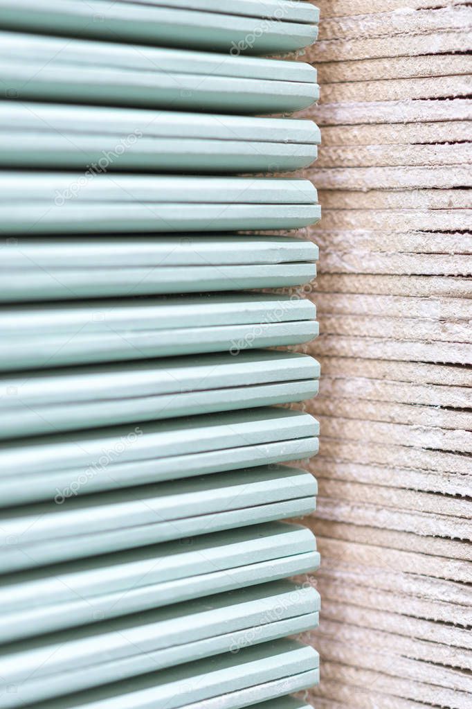 Gypsum plasterboard in the pack. The stack of gypsum board preparing for construction. Pallet with plasterboard in the building store. Construction Materials. Drywall warehouse. vertical photo