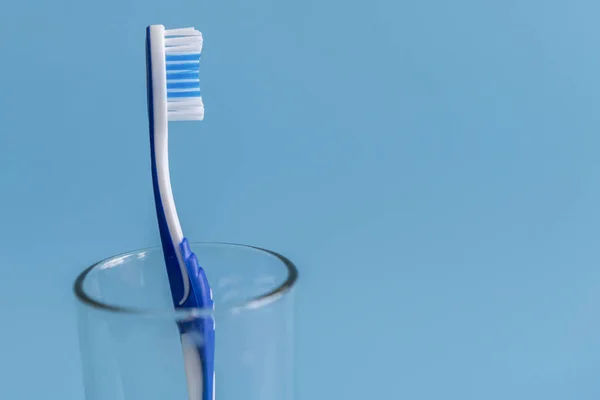 Brosse Dents Dans Verre Sur Fond Bleu — Photo