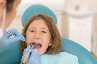 Açık ağız, diş hekimi ile genç çocuğun makro yakın çekim. Diş check-up dişçi ofisinde. Dişçi kız diş diş hekimleri sandalyede incelenmesi