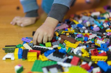 Yerdeki renkli plastik tuğla kapatın. Erken öğrenme. Çocuk yerdeki plastik Oluşturucu. Küçük bir Oluşturucu çocuk el oynayın
