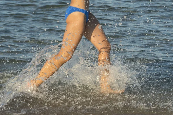 セクシーな若いブルネットの女性または捨てられた熱帯のビーチと青い空でサーフィンを介して実行されているビキニを着ている少女 海沿い走っている若い女性 — ストック写真