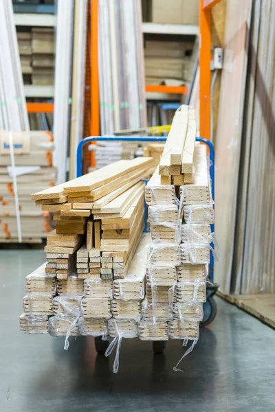 construction cart in the building store. Carts loaded with boards. shop of building materials. Racks with boards, wood and building material. loaded cart in a hardware store. vertical photo.
