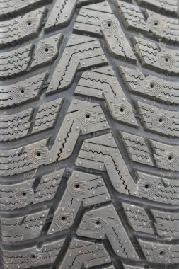 Yakın çekim kış lastiği basmak. Dokulu lastik sırt. Yepyeni modern kış araba lastik parçası. dikey fotoğraf.