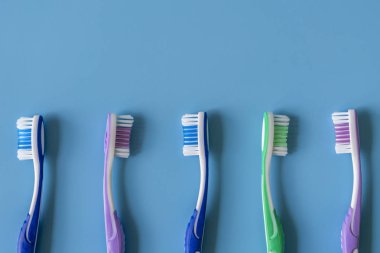 Mavi arka plan üzerinde diş fırçaları. Düz renkli arka plan üzerinde el ile diş fırçası ile kompozisyon yatıyordu, yakın çekim. kopya alanı.