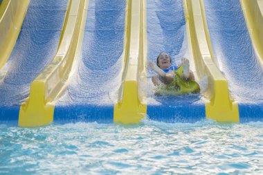 Güzel kız bir su kaydırağı sürme. mutlu kadın kauçuk halka turuncu slayt aqua park tarafından aşağı gidiyor. Yaz tatili. Hafta sonu resort.