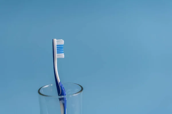 Brosse Dents Dans Verre Sur Fond Bleu — Photo