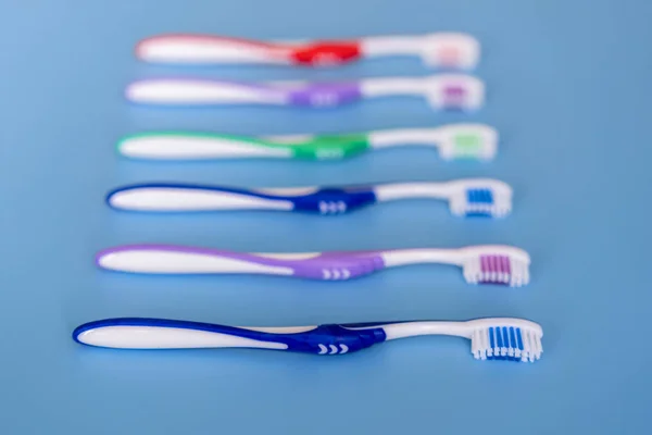 Toothbrushes on blue background. Flat lay composition with manual toothbrushes. Multi-colored toothbrushes on a blue background. close up.