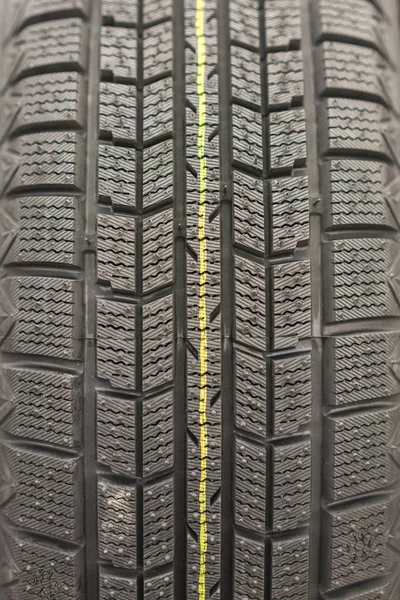 特写冬季轮胎胎面 有纹理的轮胎胎面 部分全新的现代冬季汽车轮胎 垂直照片 — 图库照片