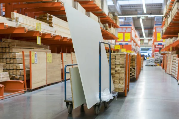 construction cart in the building store. Carts loaded with boards. shop of building materials. Racks with boards, wood and building material. loaded cart in a hardware store.