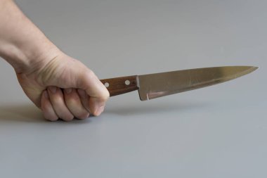 Elini gri arka plan üzerinde bir bıçakla. Şiddet kavramı