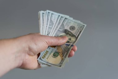 El dolar üzerinde gri bir arka plan ile. dolar para Finans döviz gri arka plan üzerinde elinde. dikey fotoğraf